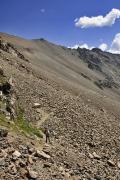 Le col est visible au-dessus des pierriers à gauche